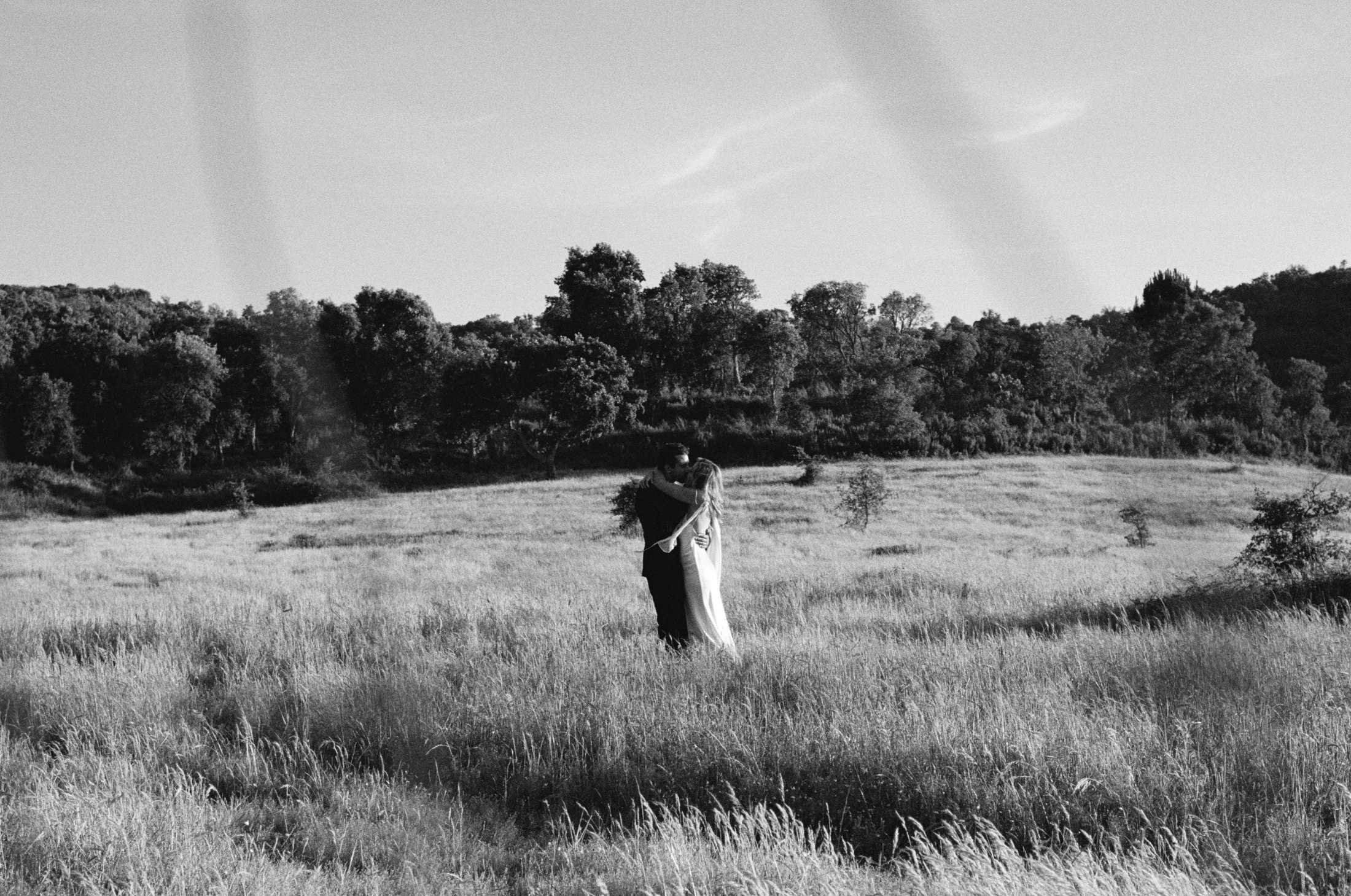 A couple together in an open field — fine-art wedding photography